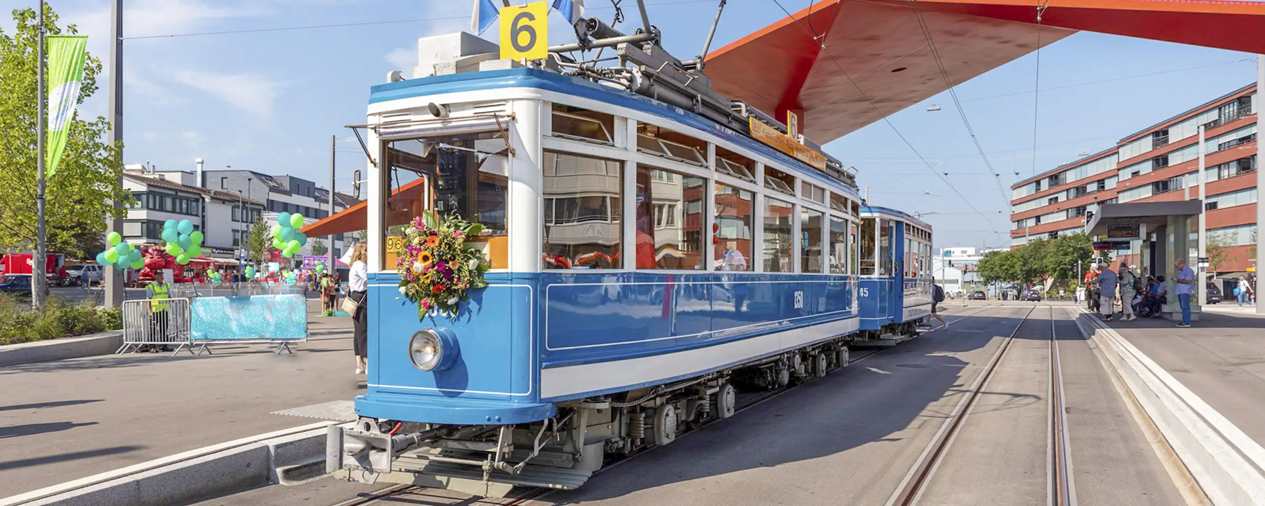 Mit Blumen geschmücktes, altes Tram der VBZ an einer neuen Limmattalbahnstation