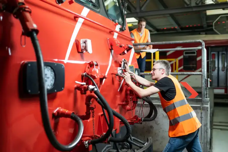Enotrac Mitarbeiter beim Messen einer Steckdose mit dem Multimeter an einer Lokomotive