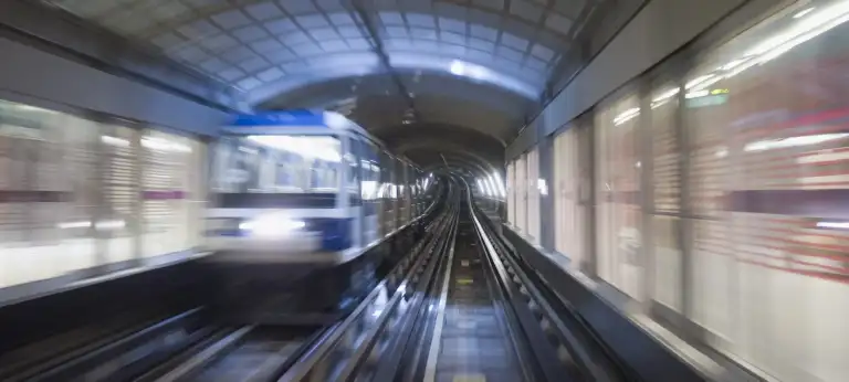 Verschwommen-dynamische Aufnahme einer U-Bahn in einer Station mit entgegenkommendem Fahrzeug