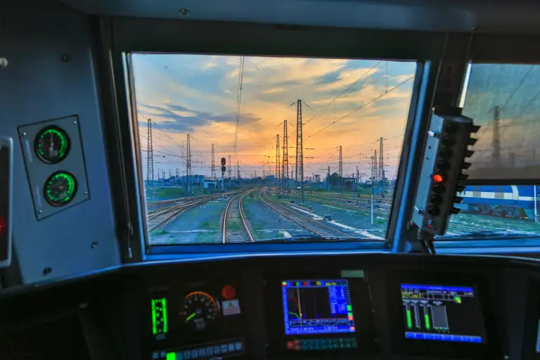 Aussicht aus einem Führerstand auf ein Gleisfeld bei Sonnenuntergang