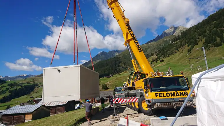 Ein Betonelement wird von einem Lastwagen von einem Kran abgeladen