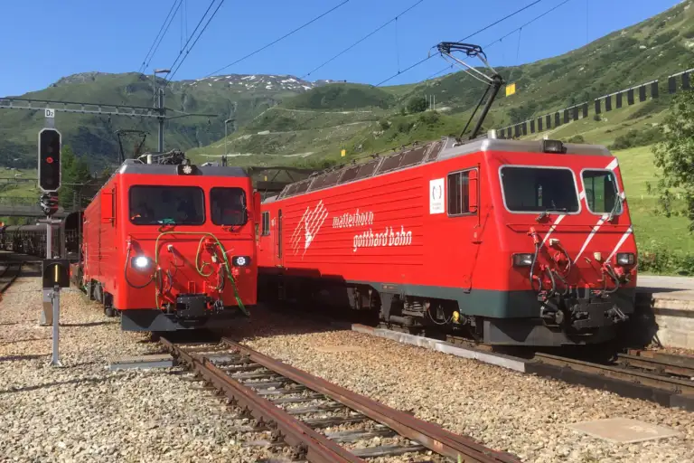 Die Refit-Prototyplokomotive HGe 4/4 II 106 (links) trifft anlässlich der Autozug-Inbetriebsetzungsfahrten im Furka-Basistunnel am 21.7.2021 in Realp die noch nicht umgebaute Lok 108 (rechts) an der Autorampe